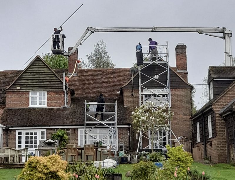 The Moss Cleaners using cherry picker and scaffolding to clean roof safely and professionally in Aldershot, Hampshire